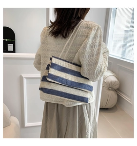Detail view of large blue and white striped woven tote bag showing texture and drape