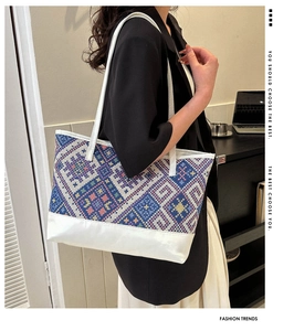 Ethnic style tote bag with geometric pattern and white panel shown in office setting