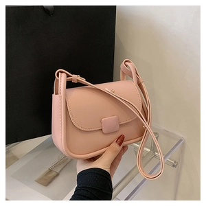 Détail du petit sac bandoulière rose minimaliste avec boucle carrée et bandoulière