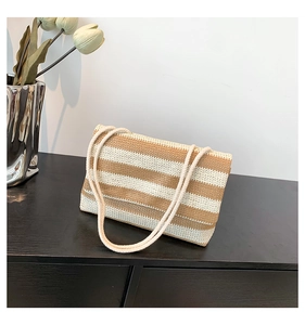 Detail of striped woven tote bag with rope handles and brown and beige knit texture