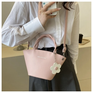 Detail of pink fashion tote bag with floral charm and adjustable shoulder strap