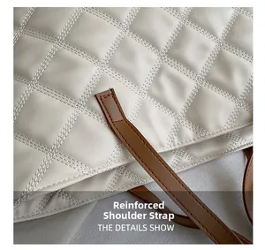 Close-up of reinforced brown leather strap stitching on white quilted tote bag details