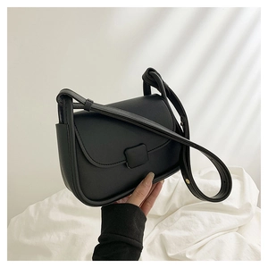 Détail du petit sac bandoulière noir en cuir avec rabat minimaliste et boucle décorative