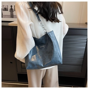 Détail du sac cabas bleu montrant la chaîne argentée et l'étiquette Fashion & Bags