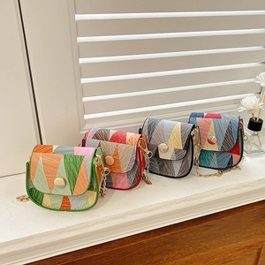 Mini geometric pattern crossbody bags with gold chains in four colors on a bright windowsill
