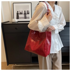 Vue détaillée d'un cabas en cuir ciré rouge foncé avec étiquette mode et bandoulière