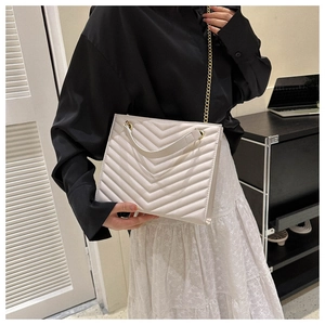 Detail of ivory V-quilted leather tote bag with gold chain strap and handle