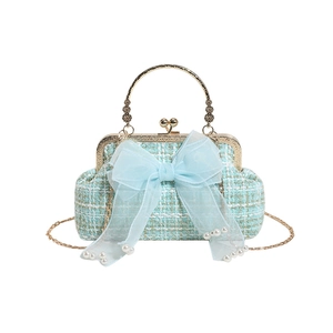 Light blue tweed handbag with organza bow and pearl details on white background