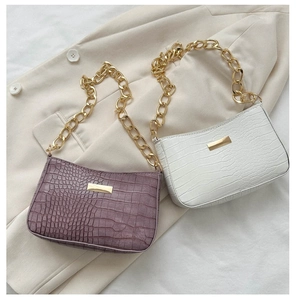 Detail of purple and white faux crocodile bags with chunky gold chain shoulder straps