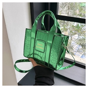 Detail of metallic green mini bag with crocodile texture and metal handle