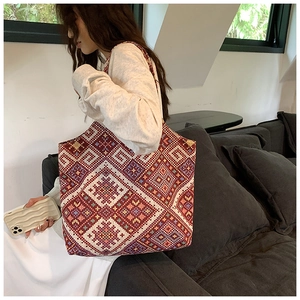 Ethnic geometric pattern tote bag shown over-the-shoulder in a casual home setting