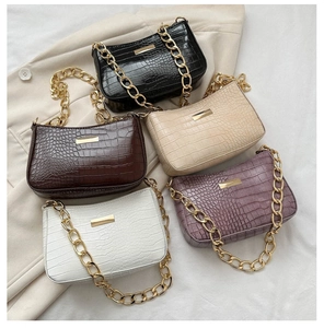 Detailed shot of textured faux crocodile leather bags in five colors with gold chains