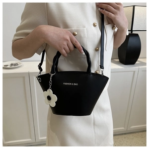 Detail of black leather basket bag with floral charm and Fashion & Bag printed text