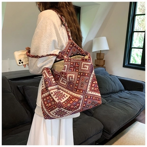 Ethnic style jacquard woven tote bag with geometric patterns shown on a model's shoulder