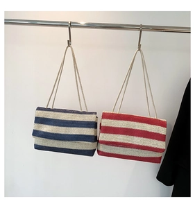 Detail of striped woven tote bags with thick rope straps in navy and red summer styles