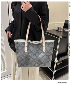 Détail du cabas gris matelassé avec anses en cuir blanc et rivets dorés brillants