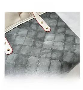 Détail du sac cabas gris à carreaux avec poignées en cuir blanc et rivets dorés
