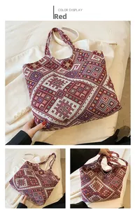 Detail view of large red ethnic tote bag with geometric woven pattern and wide handles
