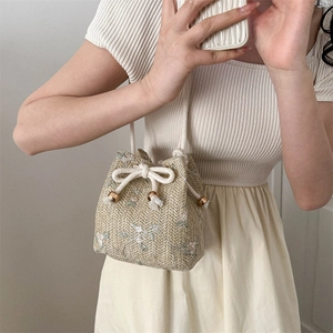 Sac seau en paille beige avec broderie florale et cordon pour un style d'été