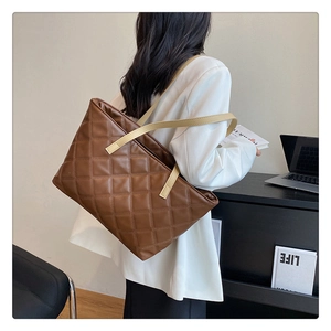 Macro detail of the brown quilted faux leather texture on this large tote bag