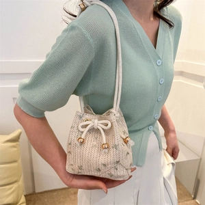 Sac seau en paille crème avec broderie florale verte et bandoulière en cordelette