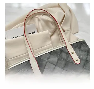 Détail du sac cabas matelassé avec poignée en cuir blanc et finition rouge