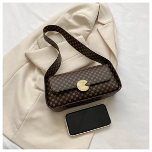 Détail d'un sac baguette marron vintage avec motif cercles et fermoir métallique doré