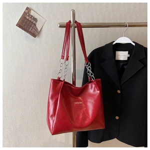 Détail du grand sac cabas rouge avec bandoulière en chaîne métallique et texture similicuir