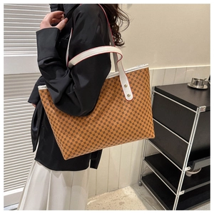 Side view of large tote bag with brown geometric pattern worn by a model