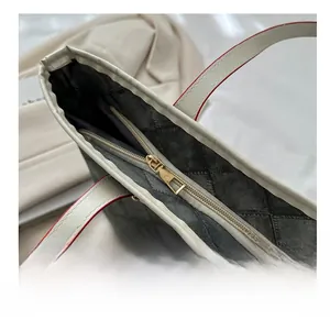 Gros plan sur la fermeture éclair dorée et les détails de couture du sac fourre-tout