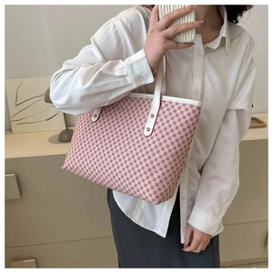 Pink tote bag detail with red patterns, white leather straps and gold metal studs