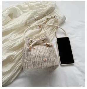 Compact woven bucket bag size comparison with smartphone showing small capacity