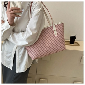 Pink tote bag with vintage monogram print and white straps worn by model