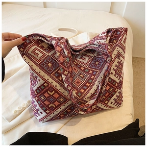 Close-up of ethnic geometric woven tote bag with red patterns and integrated handles
