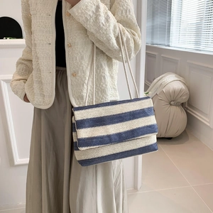 Chic blue and white striped woven tote bag with flap closure for summer vacations