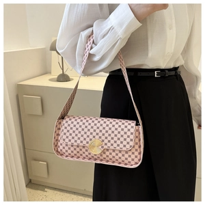 Détail d'un sac à bandoulière rose à motif avec grande boucle dorée et design à rabat