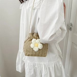 Floral straw bucket bag with white flower charm and drawstring closure for women