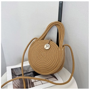 Détail d'un sac en paille tissé à la main avec bouton en bois gravé de motifs floraux