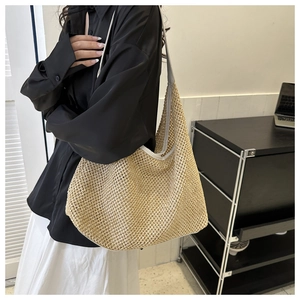 Détail du sac cabas en paille tissée avec bordure en cuir blanc montrant sa grande capacité