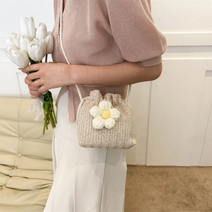 Chic woven flower bucket bag in cream white styled by a model for a trendy summer look