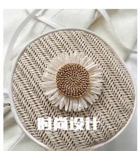 Détail du sac rond en paille avec grande marguerite blanche et fine bandoulière