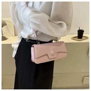 Detail view of a pale pink rectangular crossbody bag with a unique geometric flap design
