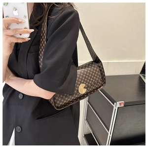 Détail du sac bandoulière marron vintage avec monogramme et fermoir doré en métal