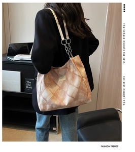 Rückansicht eines Modells mit einer großen karierten Shopper-Tasche und Kettenriemen
