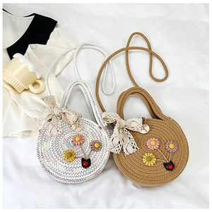 Détail de sacs en paille tressée avec fleurs, nœuds en dentelle et boutons en bois