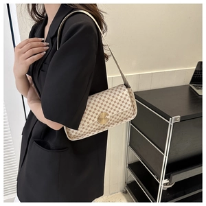 Sac rétro à pois rouges et boucle dorée porté avec une veste de blazer noire