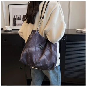 Detail der gesteppten Tragetasche mit Kettenriemen und gewebtem Fashion & Bags Label
