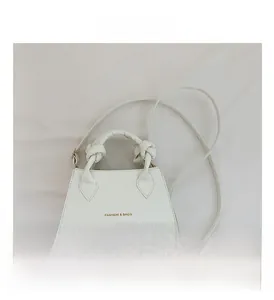 Détail du sac à main blanc à motif crocodile avec poignée nouée et logo de mode