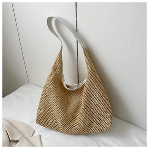Vue détaillée du sac cabas en paille tissée avec bretelles en cuir blanc et motifs ajourés