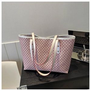 Detailed close-up of pink tote bag with geometric pattern and red-edged white handles